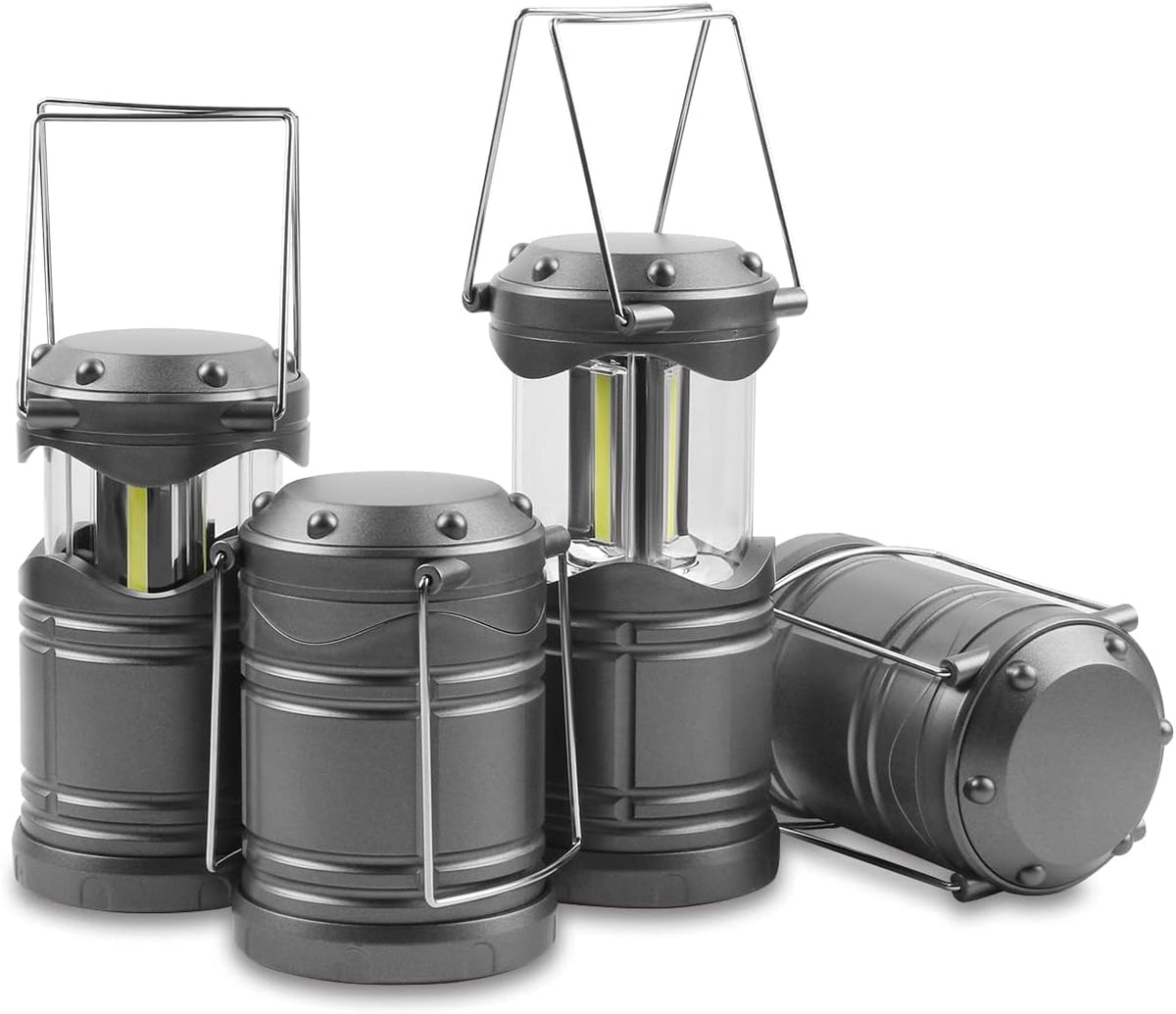 Collapsible LED camping lantern glowing on a table beside a tent at night