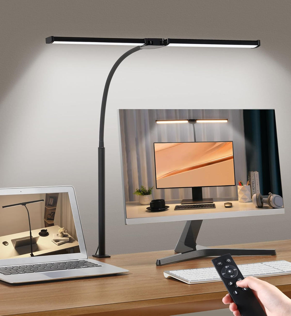 Double head LED desk lamp clamped to a desk lighting a computer monitor workspace