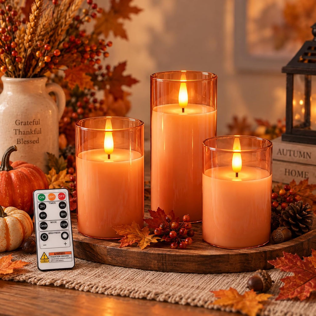 Flameless candles in grey glass holders flickering on a mantel as seasonal decor