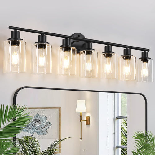 Three light bathroom vanity light with clear glass shades mounted above a mirror