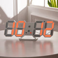 3D LED wall clock showing the time in orange digits on a table