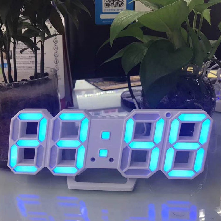 3D LED wall clock showing the time in blue digits beside a plant