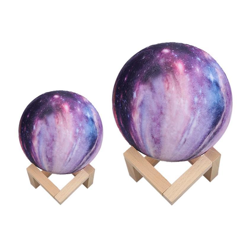 Two galaxy-print moon lamps on wooden stands, plain background