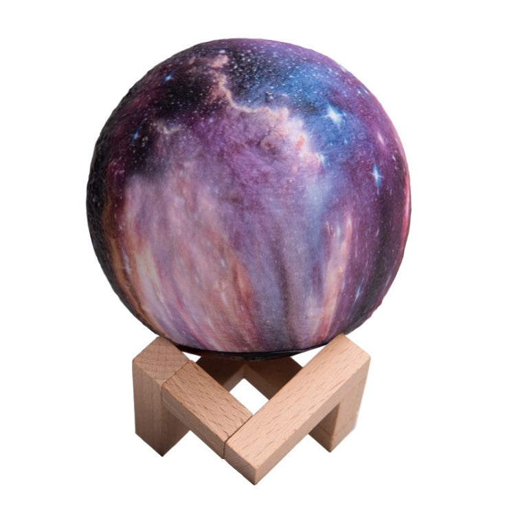Galaxy-print moon lamp on a wooden stand, plain background