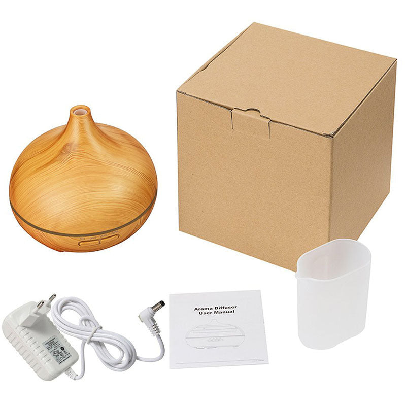 Light wood aroma diffuser shown with its box, power adapter, manual and measuring cup