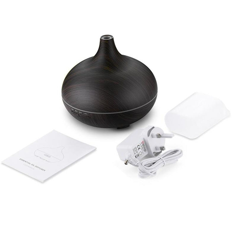 Dark wood aroma diffuser with its manual and power cable, plain background