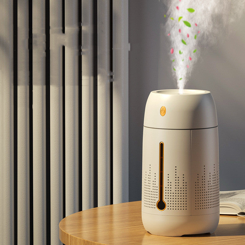 Cream aroma humidifier releasing mist on a wooden table