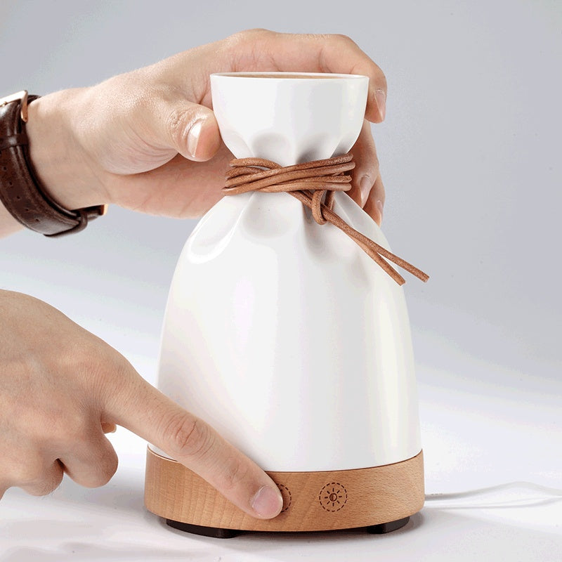 Hand loosening the drawstring top of the sack-shaped diffuser