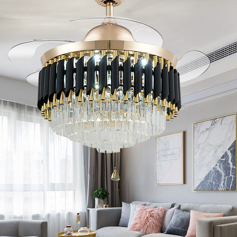 Crystal ceiling fan chandelier lit above a bright living room, blades extended