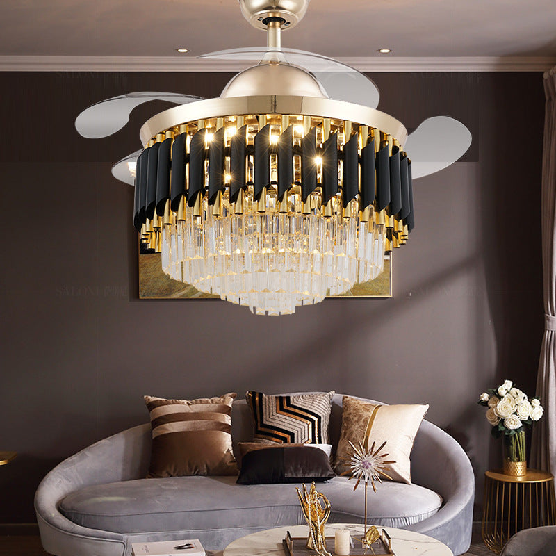 Crystal ceiling fan chandelier lit above a curved sofa in a brown living room