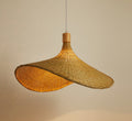 Woven bamboo pendant lit warm against a plain wall
