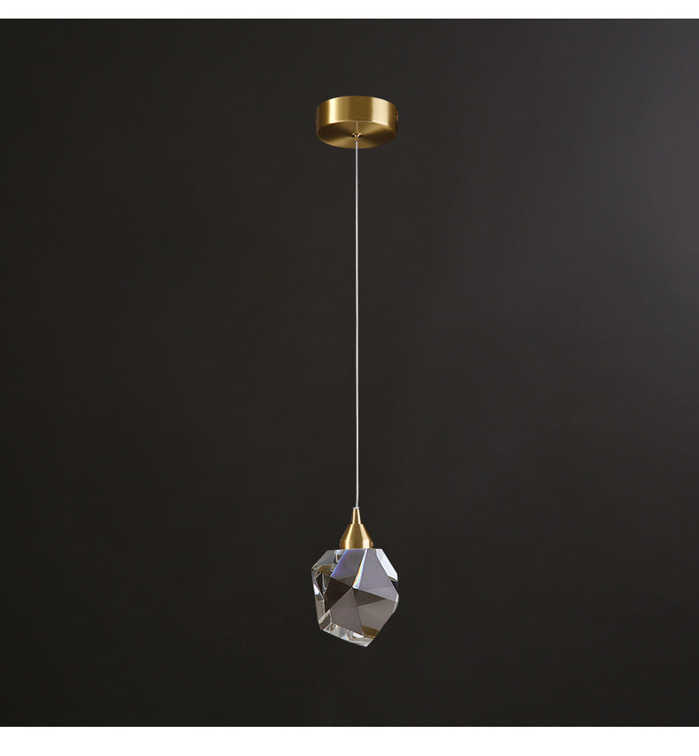 Single crystal pendant on a gold fitting against a dark background
