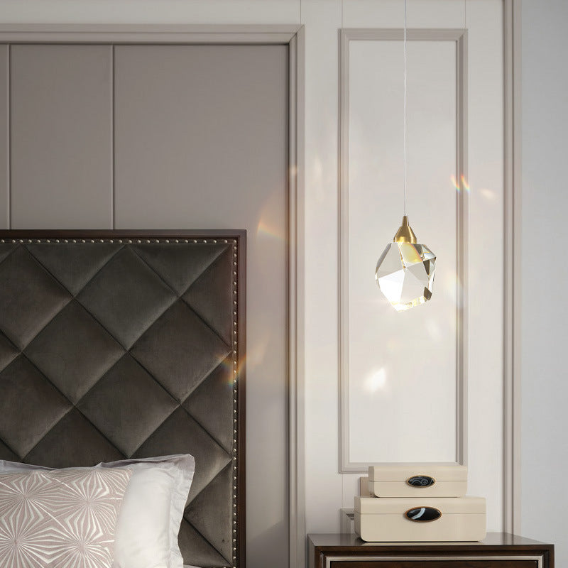 Crystal pendant hanging beside an upholstered headboard