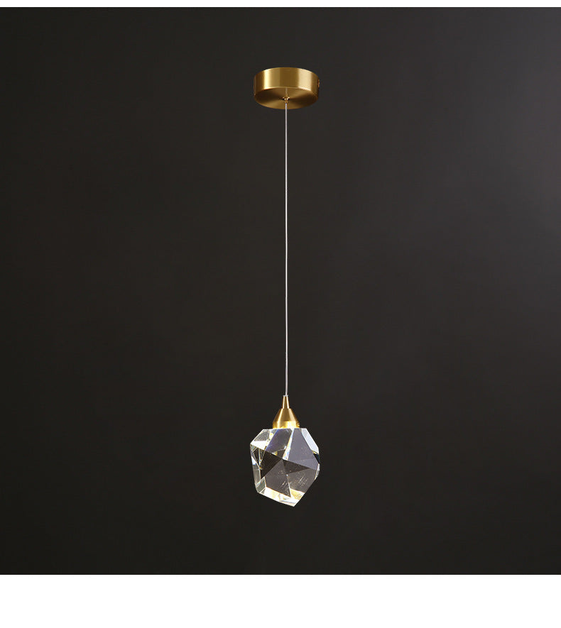 Single crystal pendant on a gold fitting, angled view, dark background