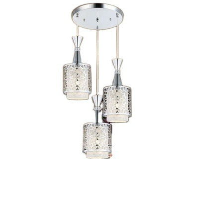 Three cylinder pendant lights hung as a cluster from a round ceiling plate