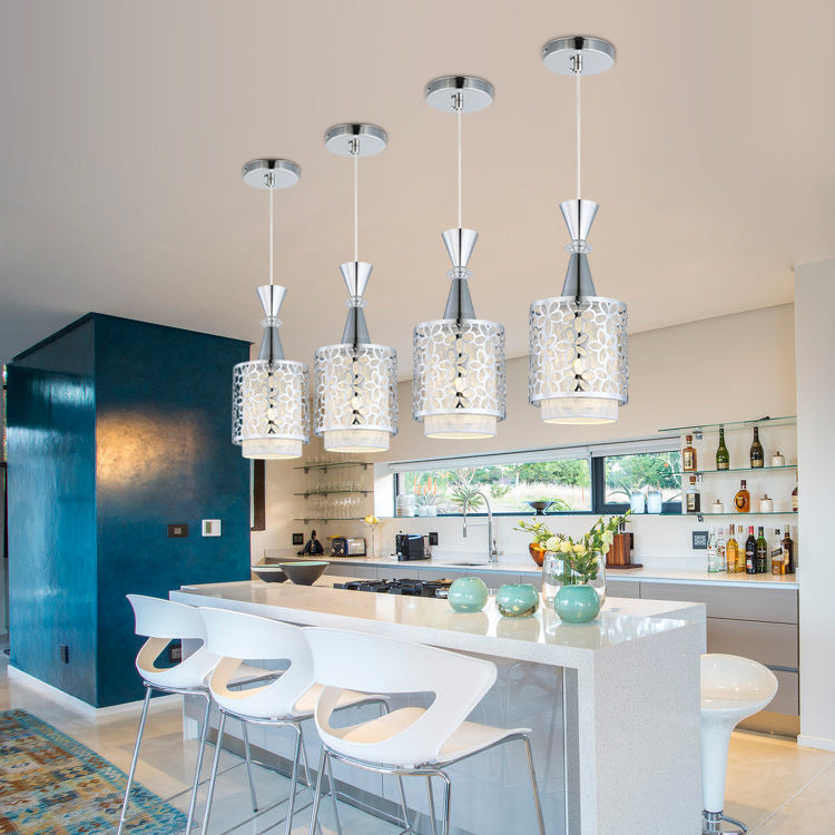 Four cylinder pendant lights above a kitchen island