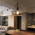 Geometric cage pendant light hanging above a dining table in an open-plan room