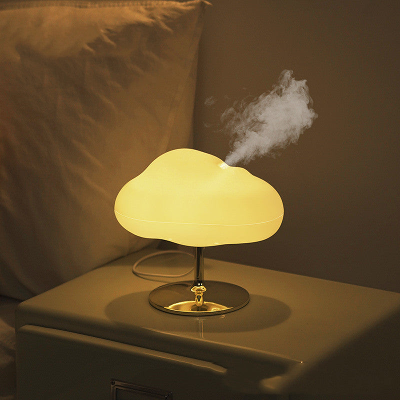 Cloud aroma diffuser glowing warm on a bedside table, releasing mist