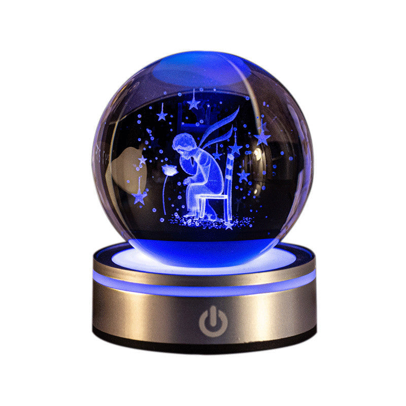 Crystal ball night light engraved with a boy under stars, lit blue on a gold base