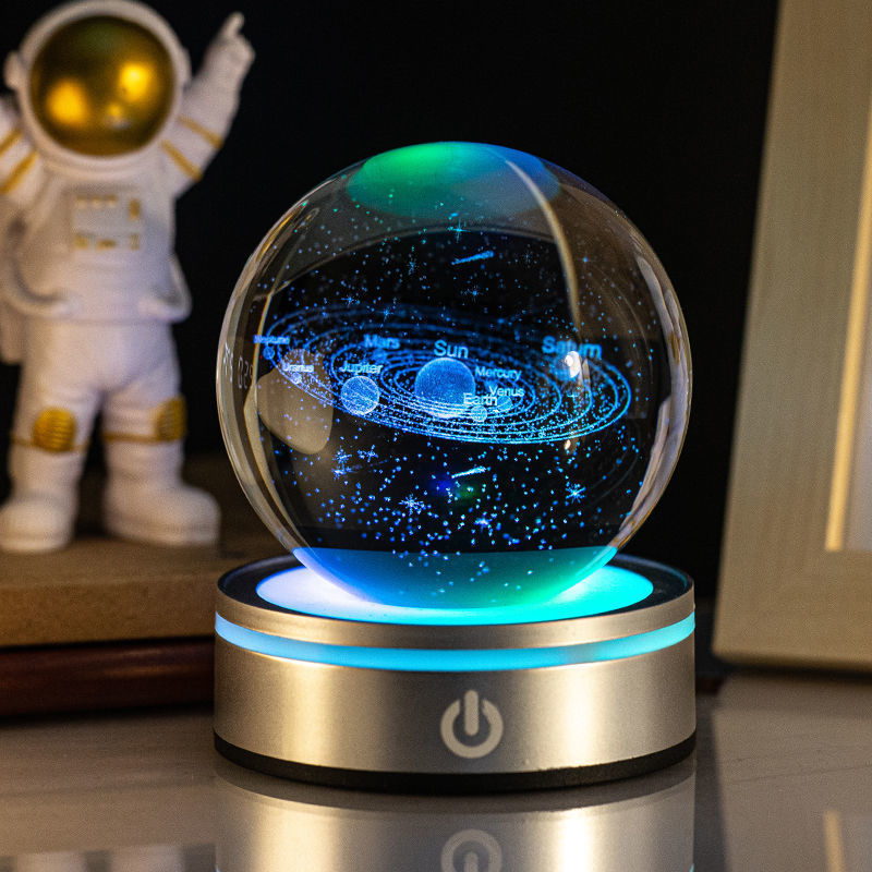 Solar system crystal ball night light lit on a teal base