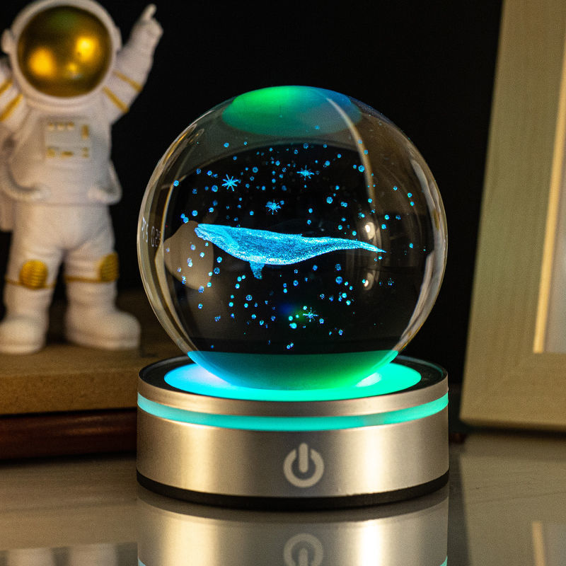 Whale crystal ball night light lit green on a silver base