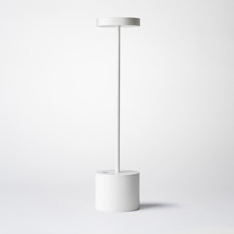 White cordless aluminium table lamp, plain background