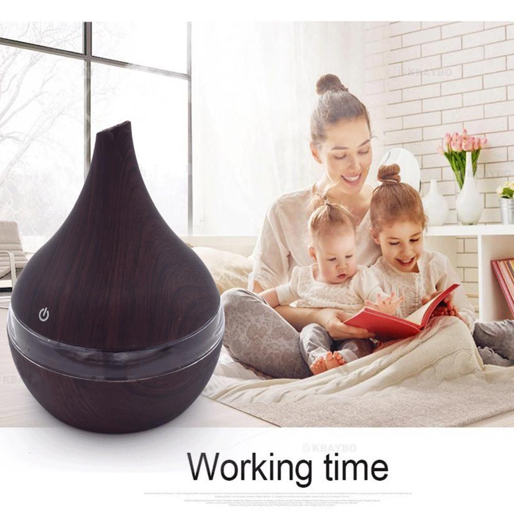 Dark wood-grain diffuser running while a parent and children read together