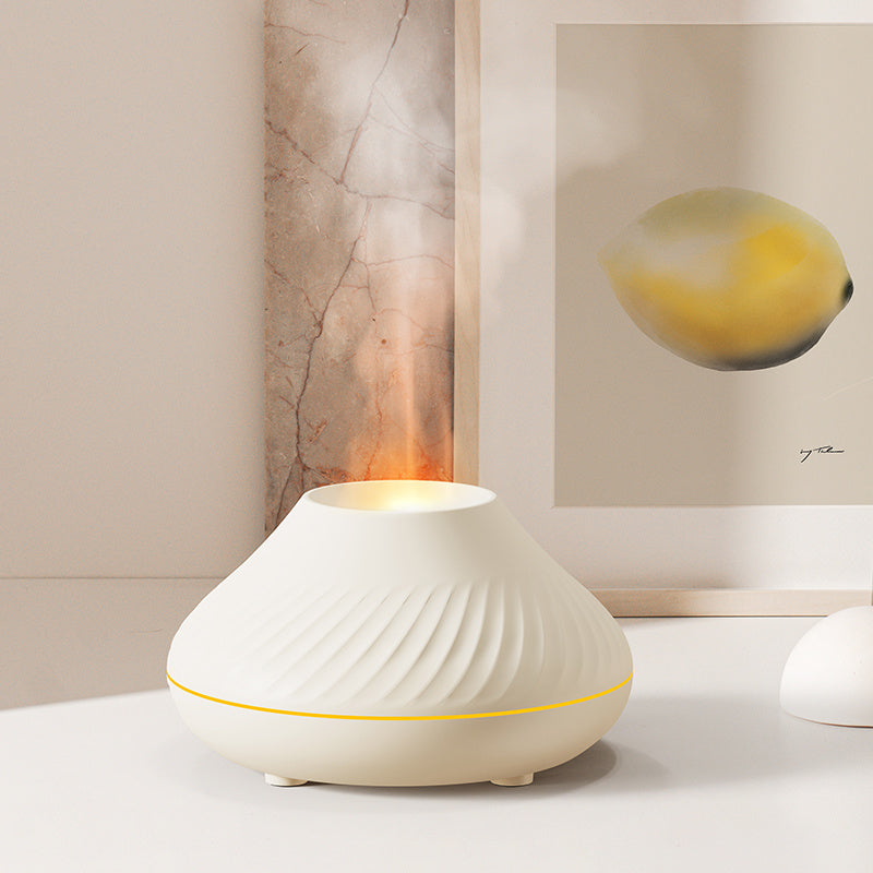 White ribbed aroma diffuser releasing mist on a pale surface
