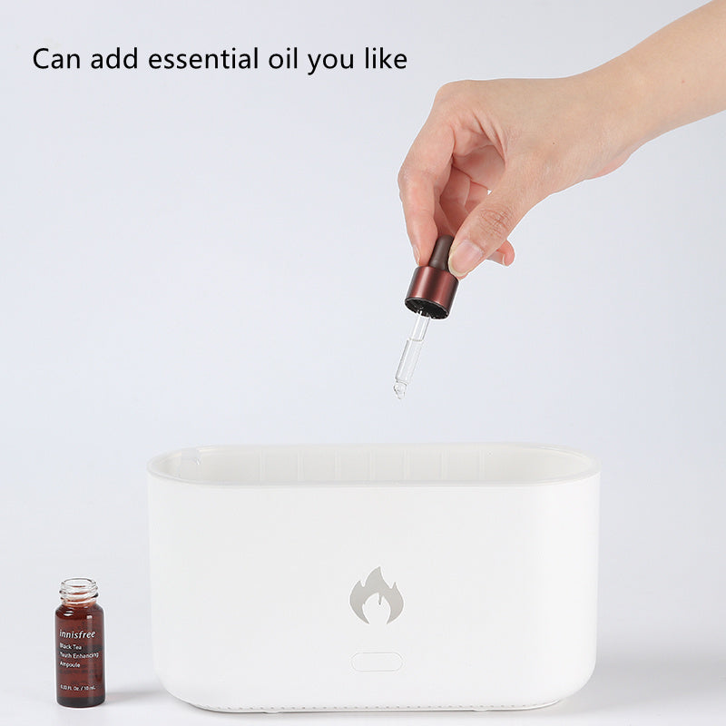 Hand adding essential oil drops into the open water tank of the white diffuser