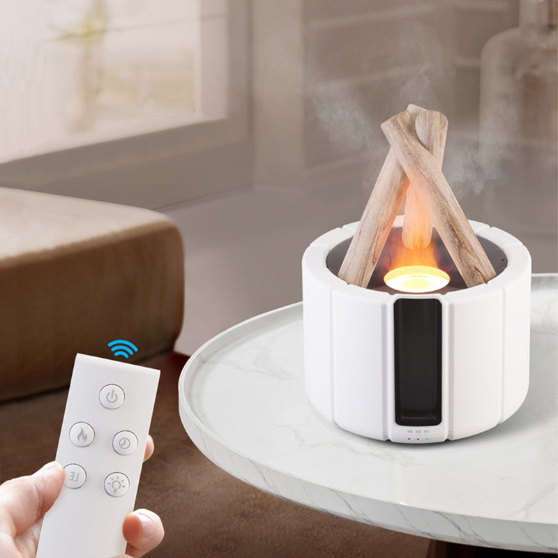 Hand holding the remote beside a white campfire diffuser on a marble table