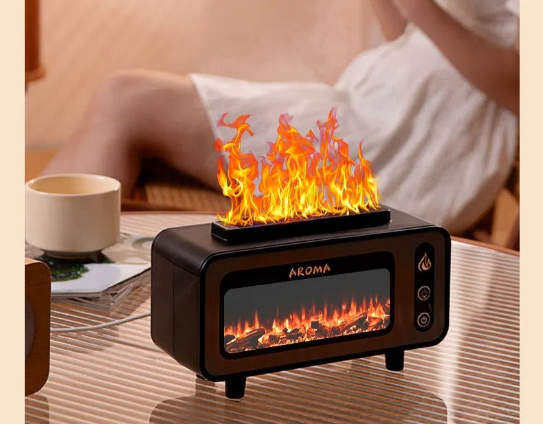 Black fireplace aroma diffuser running on a table beside a cup