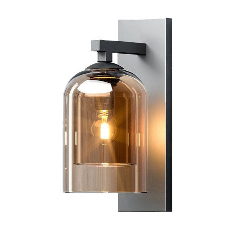 Amber glass wall sconce lit on a grey mounting plate