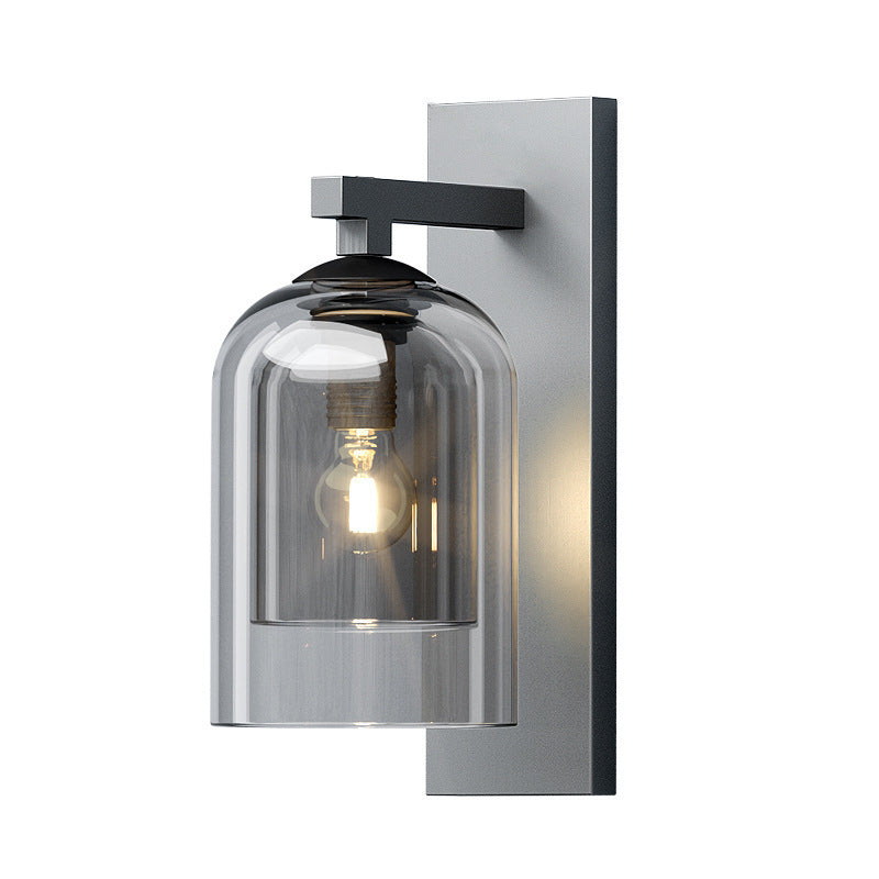 Smoke glass wall sconce unlit on a grey mounting plate