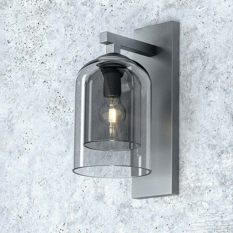 Smoke glass wall sconce mounted on a concrete wall, unlit