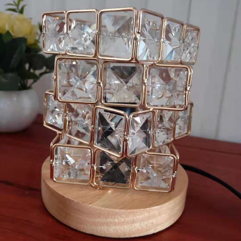 Clear crystal cube lamp on a wooden base, angled view, unlit