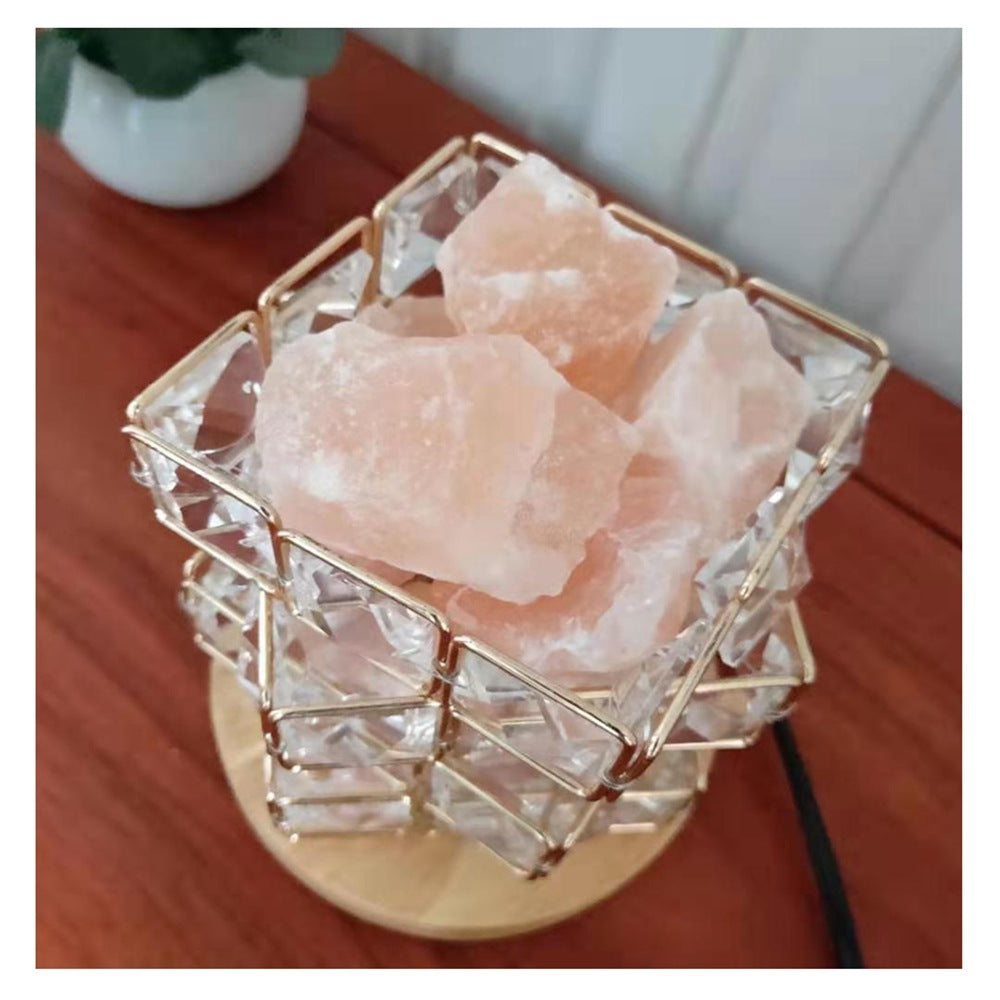 Crystal frame filled with pink Himalayan salt rocks, unlit, on a wooden table