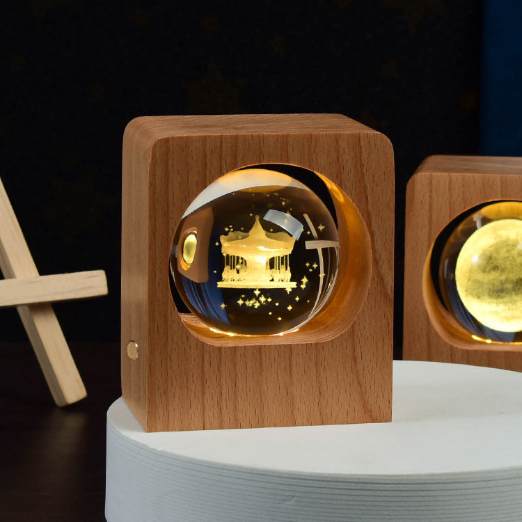 Crystal ball with a castle engraving lit inside a square wooden frame