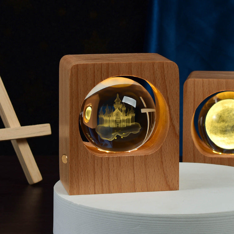 Crystal ball with a castle and stars engraving lit inside a wooden frame
