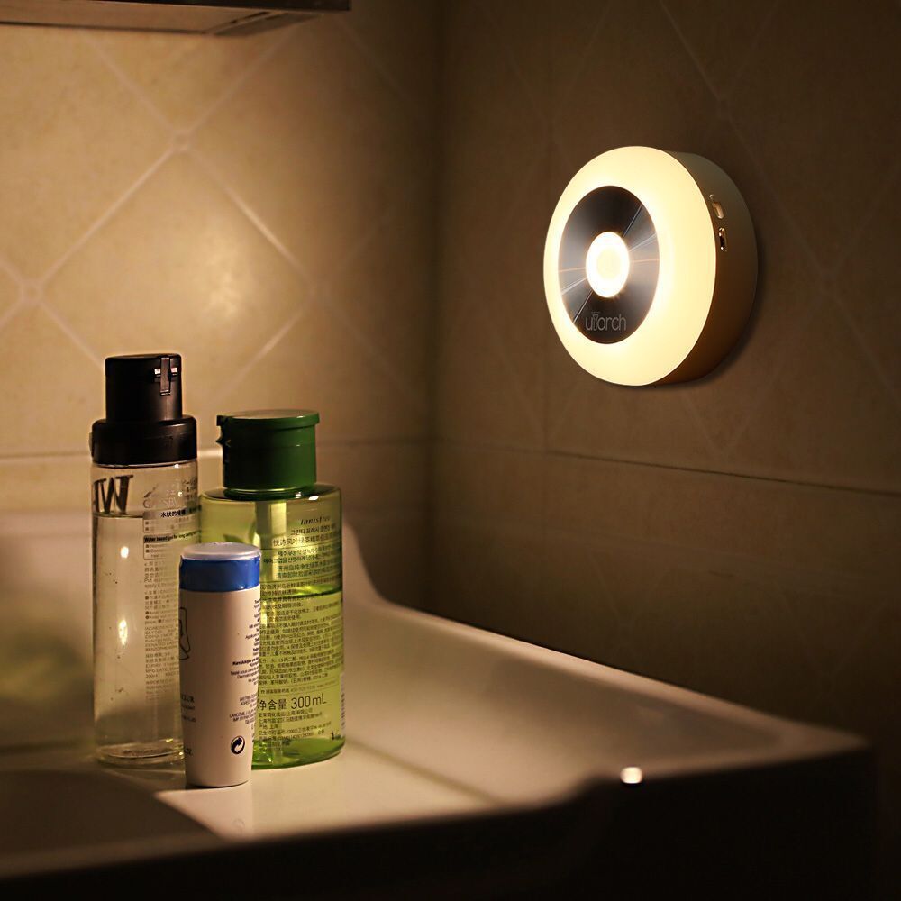 Round night light lit warm above a bathroom counter with toiletries