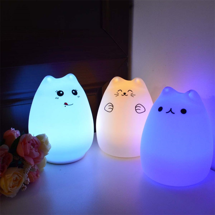 Three silicone cat night lights lit blue, warm white and dark blue