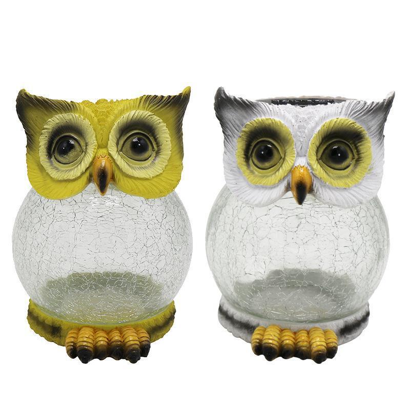 Two owl solar garden lights, one yellow and one grey, unlit