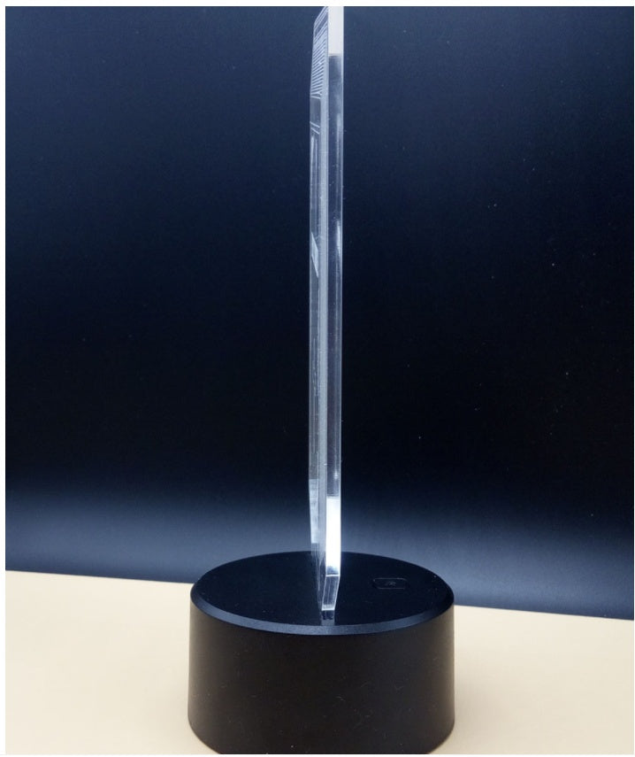 Clear acrylic panel standing in the black lamp base, unlit