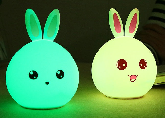 Two silicone rabbit night lights lit green and yellow-green