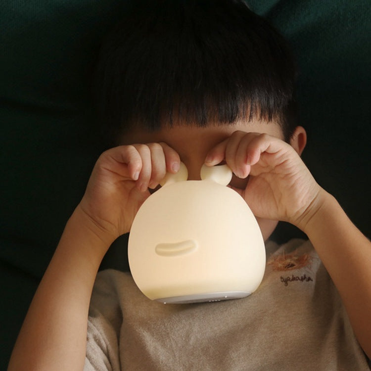 Child holding the lit silicone slug night light up to their face