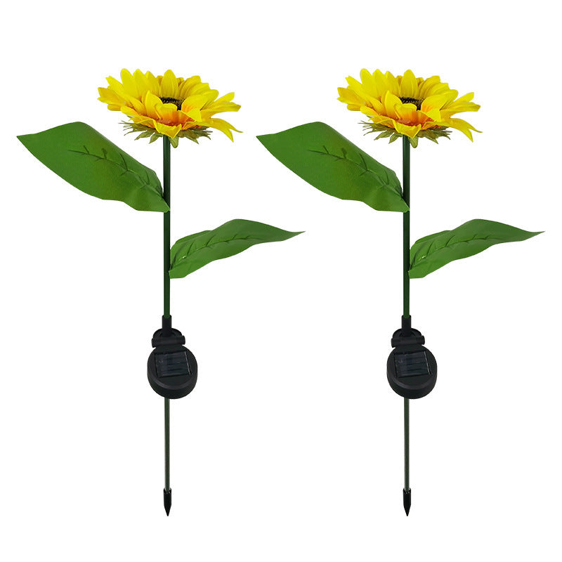 Two sunflower solar garden lights on stakes, unlit, plain background
