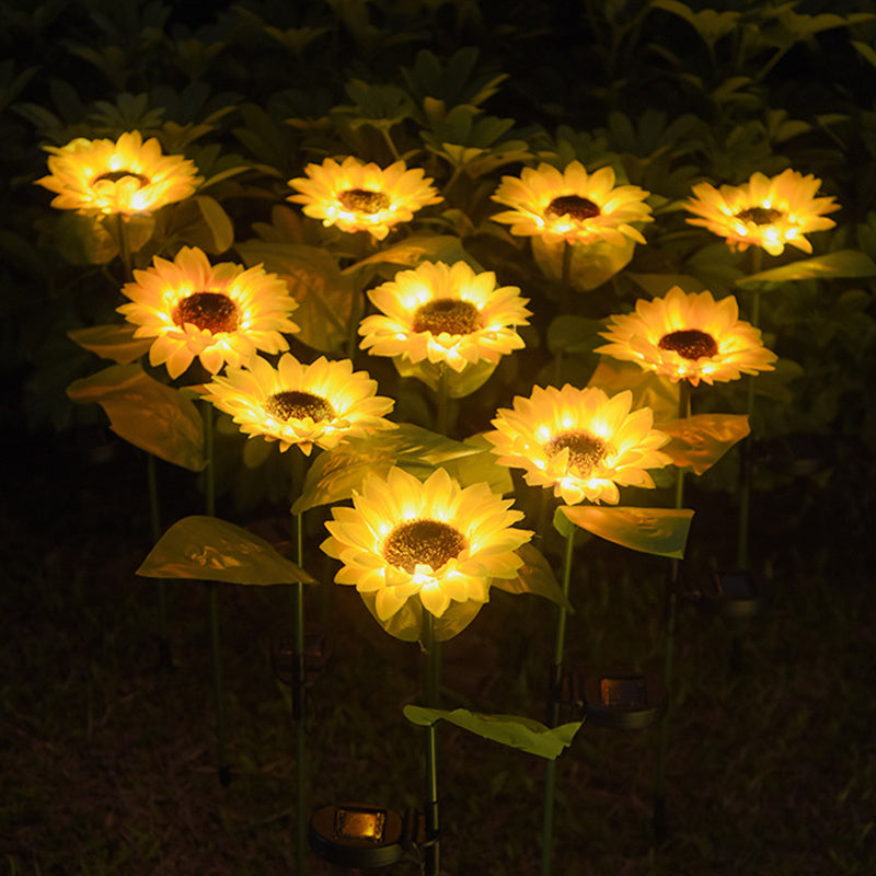 A cluster of sunflower solar lights glowing warm in a garden at night