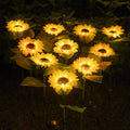 A cluster of sunflower solar lights glowing warm in a garden at night