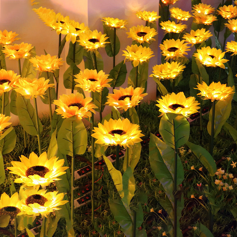 A dense group of sunflower solar lights glowing warm against a wall