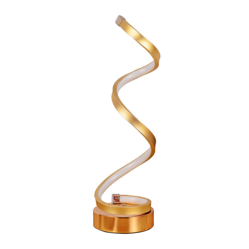 Gold spiral LED table lamp on a round base, plain background