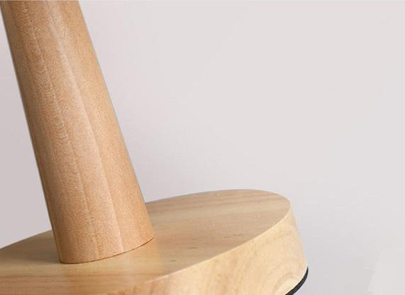 Close-up of the turned wooden base and stem of the pleated table lamp